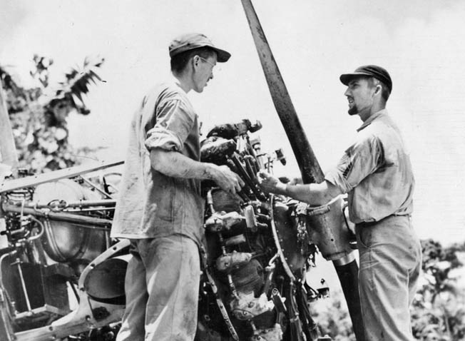 Mechanics work on a plane at Henderson Field. These tireless ground crewmen were often tasked with scrounging spare parts to keep P-400s of the 67th Fighter Squadron flying.