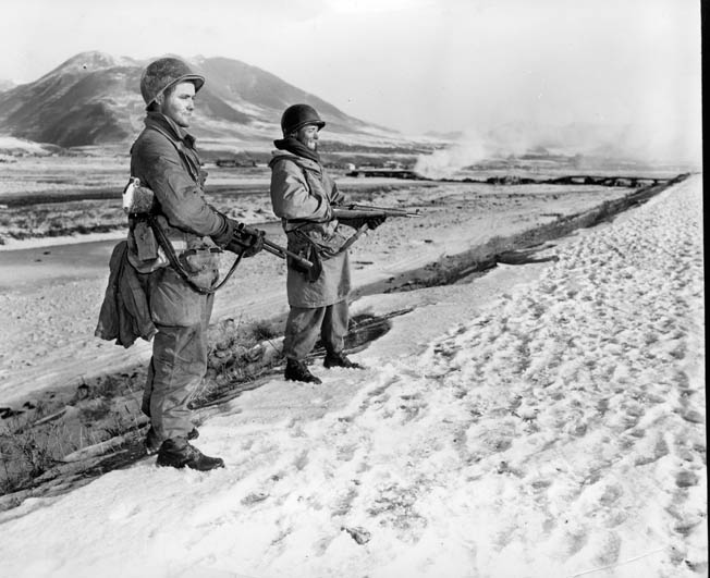 Two soldiers of the U.S. Army 7th Infantry Division patrol the banks of the Yalu River at the Chinese border.