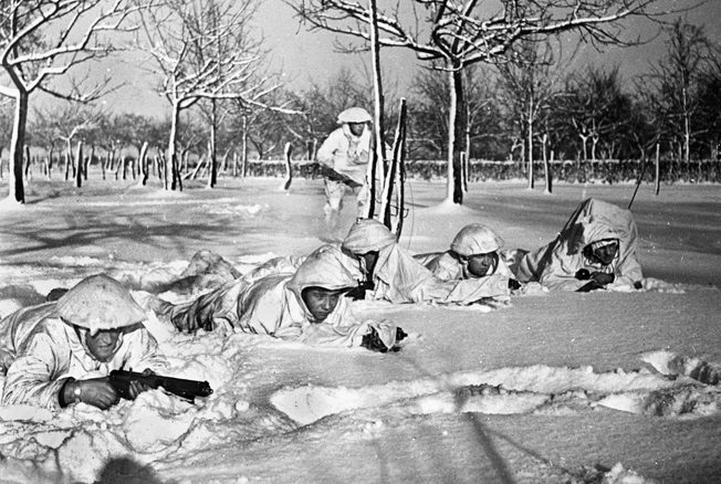 British Commandos in snow-camouflage uniforms on a reconnaissance mission before the Allied offensive toward Germany and the lower Roer River.