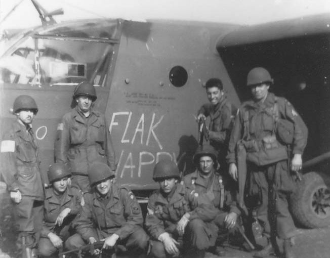 Members of the 319th Communications Section pose outside their glider, Flak Happy, on September 18. They are, left to right, kneeling: T-4 Ed Ryan, First Sergeant Irving Rosenwasser, George Barron, and Dimitrios Vassal. Standing, left to right: glider pilot Marks, Corporal Ernest Osborne, Seymour Englander, and Motor Pool Sergeant Jarret Fury. 