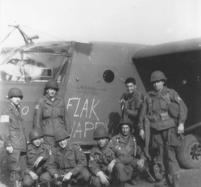Members of the 319th Communications Section pose outside their glider, Flak Happy, on September 18. They are, left to right, kneeling: T-4 Ed Ryan, First Sergeant Irving Rosenwasser, George Barron, and Dimitrios Vassal. Standing, left to right: glider pilot Marks, Corporal Ernest Osborne, Seymour Englander, and Motor Pool Sergeant Jarret Fury.