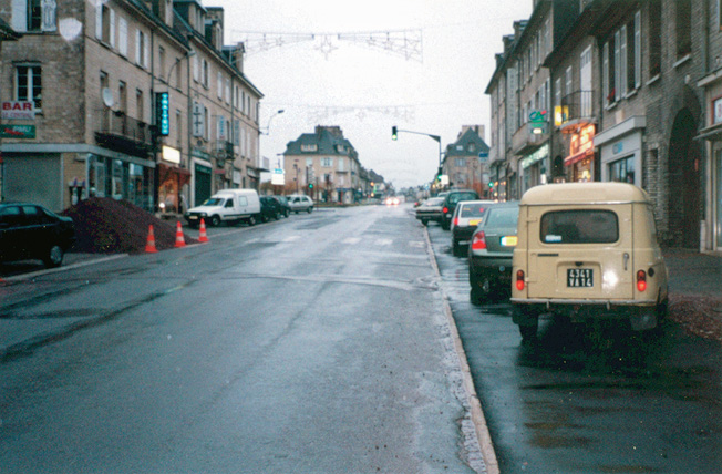 The scars of battle all but gone, the same street in Villers-Bocage that was the scene of utter devastation in the above photo is shown today in the now-quiet French town.