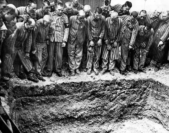 Prisoners at German-run concentration camps were segregated by nationality. Here, a group of Danes at the Dachau camp, where Jorgensen was interned, stand around one of the burial pits they were forced to dig for their deceased countrymen. 