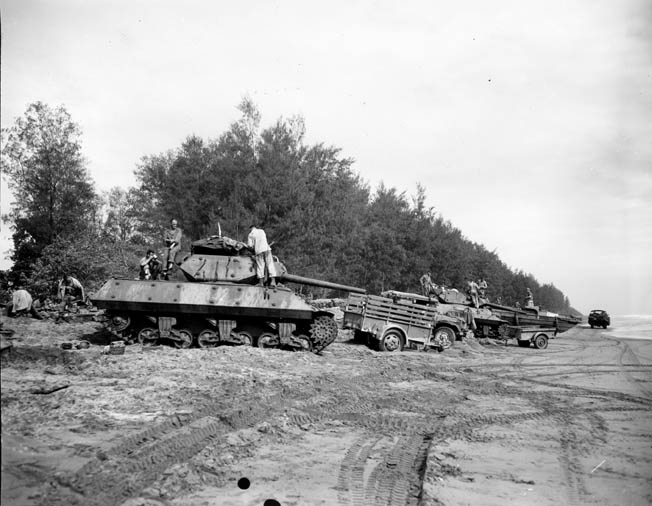 An American tank destroyer and other vehicles attached to the 32nd Infantry Division are readied for an advance against Japanese positions.