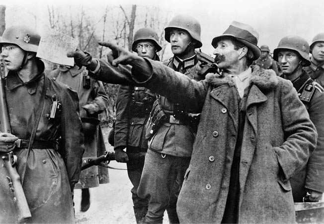 A Yugoslav civilian, perhaps under duress, points to positions he believes are occupied by units of the Yugoslav Army. His Nazi interrogators appear in a hurry to continue their advance.