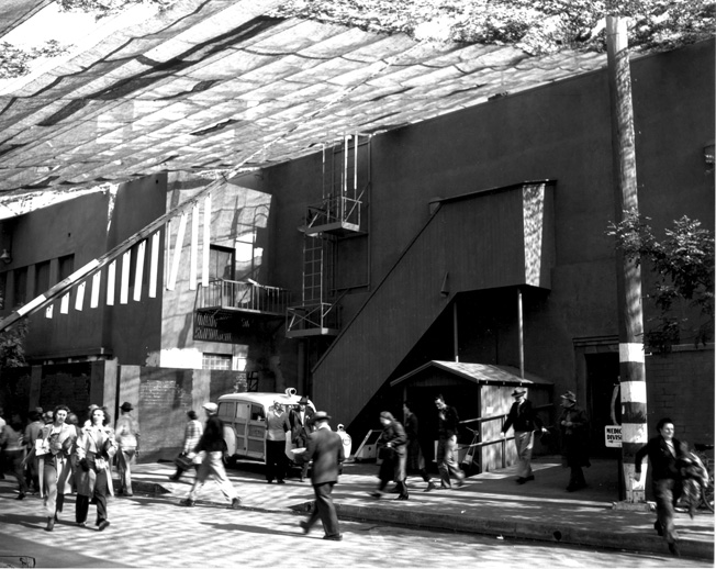 The camouflage netting at Douglas in Santa Monica stretched seamlessly from building to open areas, obscuring the edges of the buildings. Note the “woody” ambulance in the background.