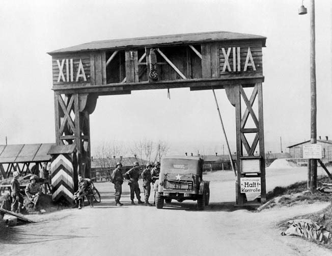 American soldiers stand around the gate of Stalag XII-A, near Limburg, Germany, the prison camp where Ray Miller was held captive in February 1945.