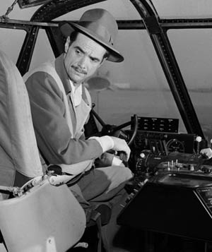 The brilliant, eccentric aviator Howard Hughes in the cockpit of his mammoth transport plane.