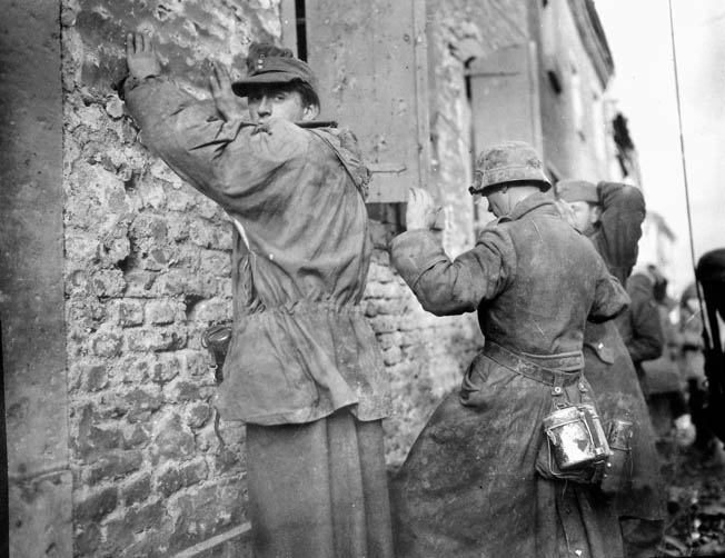 German prisoners captured by the 104th Division near Inden on October 12, 1944, keep their hands up as they wait to be searched. While guarding prisoners, Creamer accidentally discharged his pistol, nearly hiting them. 