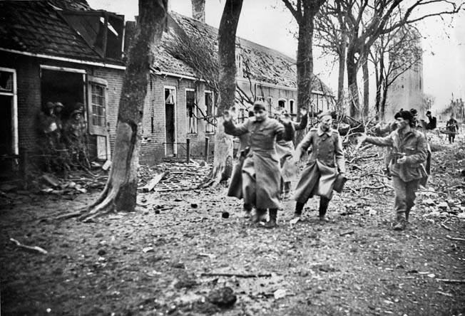 After Westkapelle was taken, German prisoners are escorted to the rear by British commandos. The port of Antwerp finally began unloading supply ships at the end of November.