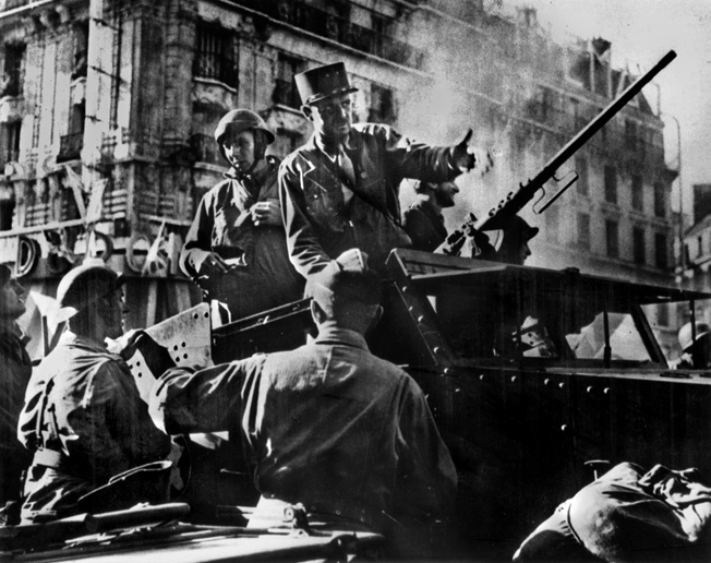 French General Jacques Philippe Leclerc, standing in his half-track, arrives in an exultant Paris after a headlong dash into the city. The French were determined to reach the capital first.