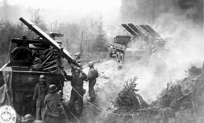 Men of the 18th Field Artillery Battalion, V Corps reload their rocket launchers in the Hürtgen Forest. Accurate and deadly American artillery fire was instrumental in holding the positions of the 2nd Ranger Battalion on Hill 400. 