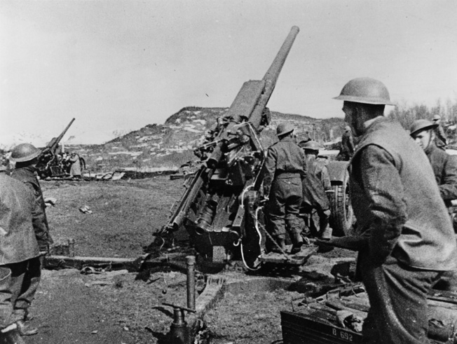 A British artillery battery fires at German positions during the Battle of Narvik, along the bleak Norwegian coastline, in June 1940. British General Claude Auchinleck commanded troops during the disappointing campaign.
