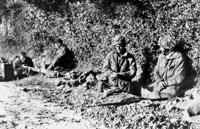 Digging in along a dirt road in Normandy, paratroopers of the 1st Canadian Parachute Brigade prepare to hold their ground against any German counterattacks. This image was taken on June 8, 1944, two days after the paras had jumped into France. 