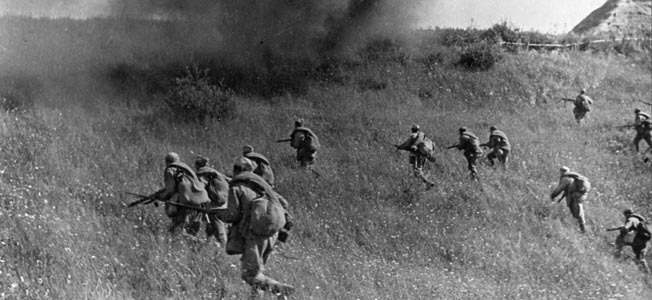Red Army infantrymen advance as a shell explodes in front of them and throws up a curtain of smoke and debris. Out of the frame, Soviet tanks have taken the lead in this assault somewhere in the Ukraine.