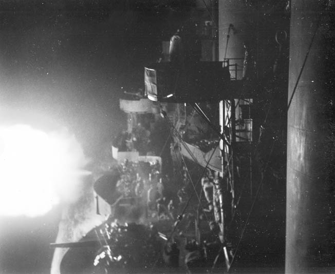One of the American warships engaged in the Battle of Kula Gulf fires its main 6-inch guns at a Japanese destroyer. The battle took place at night, favoring the Japanese, who were more experienced in nocturnal engagements.