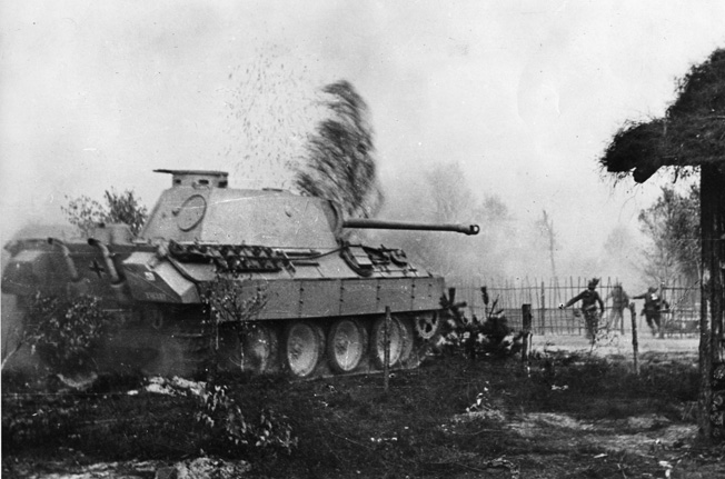Men of the Grossdeutschland Division, accompanied by a PzKpfw V “Panther” tank, enter a village in southern Russia, 1944.
