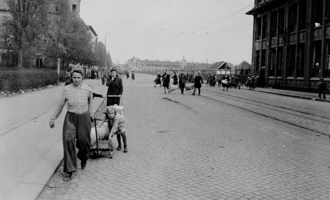 Their faces full of concern for the unknown future, Leipzig residents emerge from hiding as German resistance ends and American occupation begins.