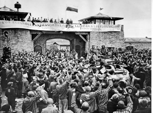 Mauthausen survivors cheer the soldiers of the 11th Armored Division of the U.S. Third Army one day after their actual liberation. The banner, written by Spanish inmates, reads, “The Spanish Anti-Fascists Salute the Liberating Forces.” 