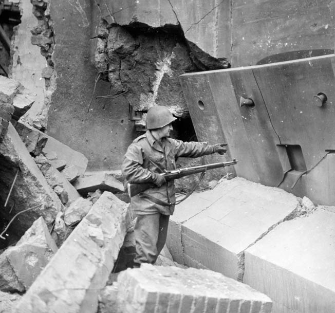 A 65th Division soldier inspects the ruins of a shattered German bunker near Saarlautern, Germany, southeast of Luxembourg on the Saar River, where Tulper briefly set up his radio.