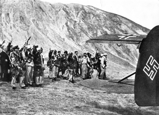 Having just completed their audacious rescue mission atop Italy’s Gran Sasso, Skorzeny’s commandos wave to the departing Benito Mussolini, September 12, 1943. 