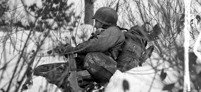 Portrait of misery: A 90th Infantry Division soldier with a Browning Automatic Rifle waits in the snow and sub-freezing temperatures near Doncols, Luxembourg, for a possible enemy attack, January 1944. 
