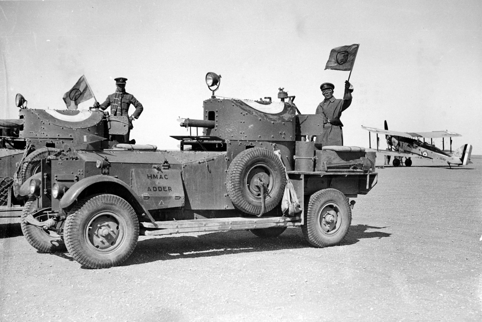 An armored car, vital to the British force crossing the desert. An RAF biplane is at right.