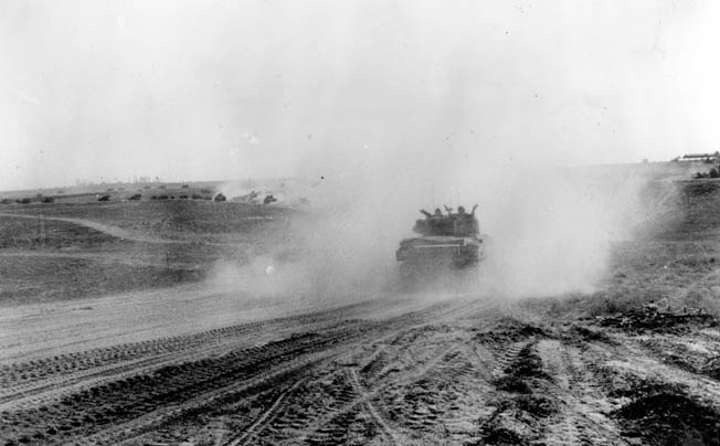 Allied armored advances across Normandy, raising a cloud of dust, as they encircle the Germans near Falaise. 