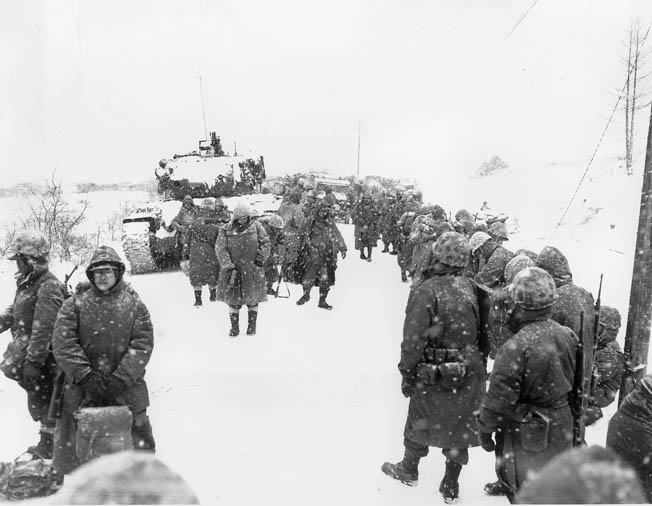 U.S. Marines suffering from exposure to freezing weather retreat from their advanced positions at the Chosin Reservoir.