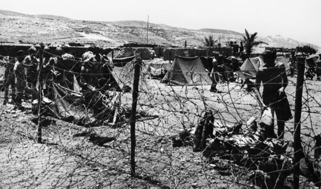 The grim surroundings of a German prison camp in North Africa are shown here. All but two of the 22 raiders who survived the Commandos’ attempt to assassinate General Erwin Rommel were captured by the Germans. 
