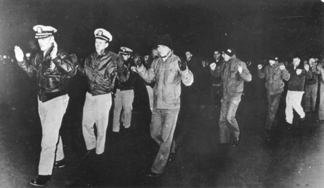 Bucher and his crew are forced to reenact their surrender two weeks after the North Korean sneak attack.