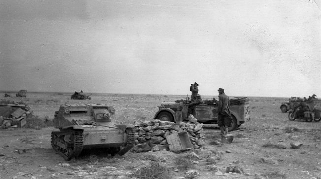 Field Marshal Erwin Rommel surveys the battle near the wreckage of a British Bren gun carrier.