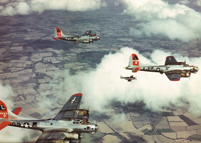 B-17s of the 8th Air Force, accompanied by fighters, cruise over England.