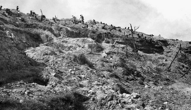 Marines climb Okinawa’s shell-pocked Sugar Loaf Hill after the battle. The 82-day Okinawa operation cost the United States more than 51,000 killed and wounded. 