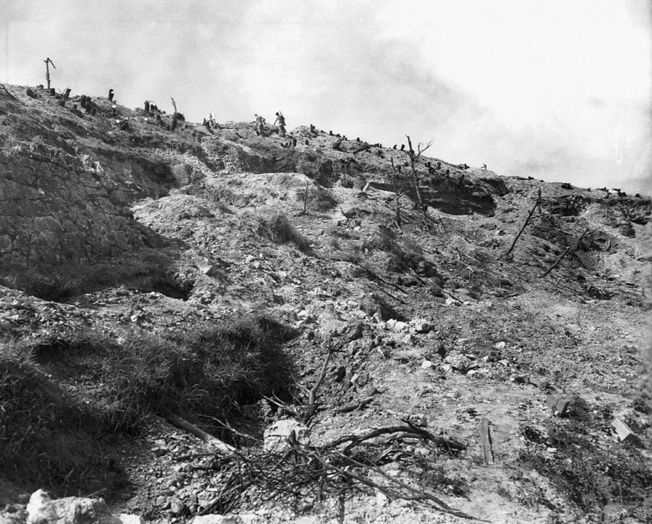 Marines ascend shell-pocked Sugar Loaf Hill after its capture. The hill alone cost the Marines nearly 4,00 casualties.