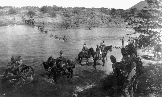 RCR soldiers cross the treacherous, swift-flowing Modder River at Paardenberg Drift, February 18, 1900.