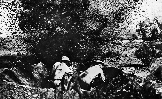 Marine defenders in a foxhole dodge an exploding shell during the first landing attempt. 