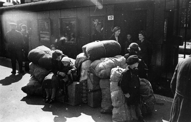 Despite their unknown future, and the fact that the Germans often attacked the trains, mothers (right) smile as they and their children prepare to depart Leningrad by rail, June–July 1941. 