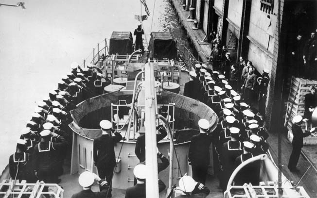 The crew of PC-1264 salutes the American flag during the ship’s commissioning ceremony, April 25, 1944. The ship became the Navy’s second ship to be manned by a mainly black crew.