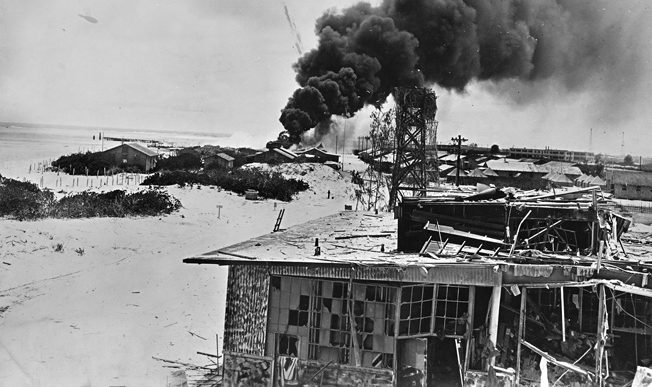 Smoke rises from burning buildings after Japanese air forces attacked the U.S. Navy base at Midway Atoll during the Battle of Midway. 