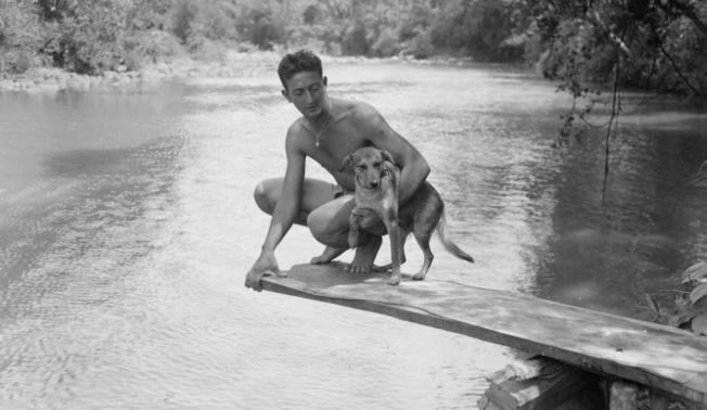 Here, Private Samson and his pal "Chips" pose on a makeshift diving board, built by his outfit for their mountain swimming hole. 