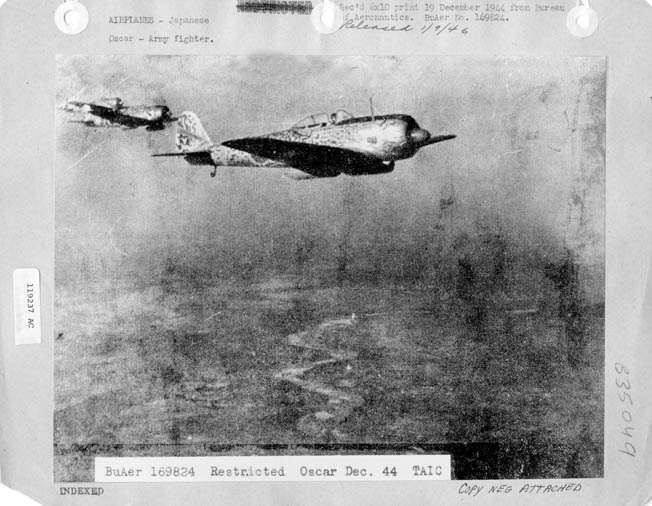 A trio of Nakajima Ki-43 Oscar fighters patrols above Japanese installations somewhere in the Pacific.