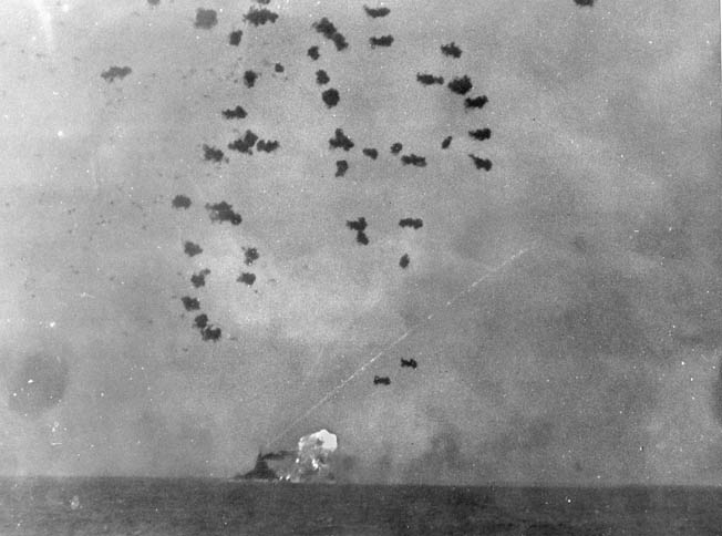 Smoke and flames belch from Nevada’s 14-inch guns as her antiaircraft guns fight off kamikaze attacks at Okinawa, April 1945.