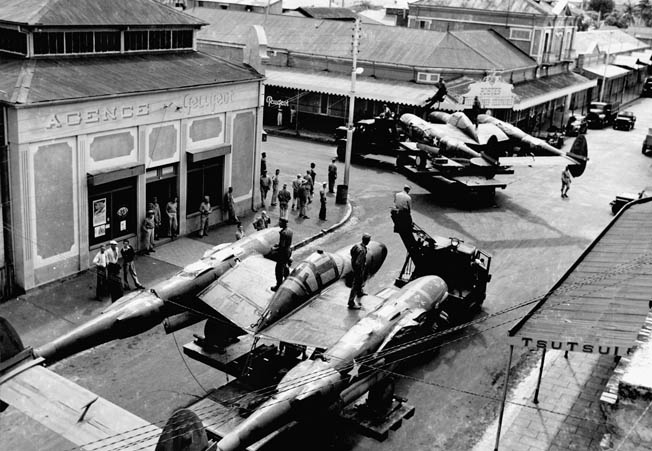 Disassembled Lockheed P-38 Lightning fighter planes, loaded on trucks, are transported through the streets of Nouméa, provincial capital of Free French New Caledonia. Despite their alliance, relations between the Americans and French authorities on the island were often strained. 