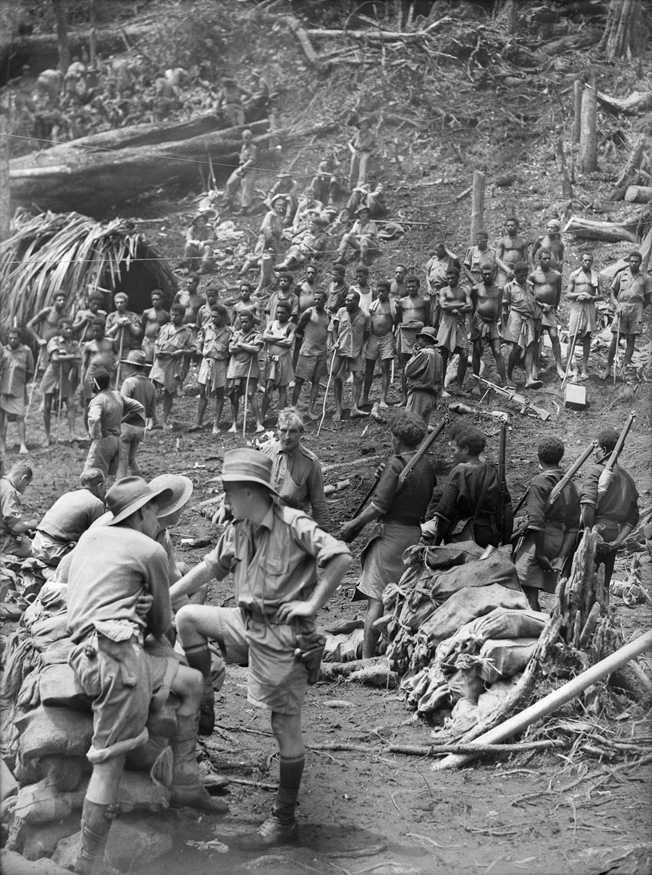 Australian troops and native New Guinea warriors assemble in the village of Eora on August 28, 1942, prior to launching an attack along the Kokokda Trail.