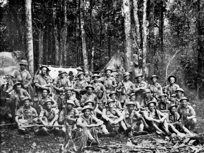 Members of 9 Platoon, A Company, 2/14th Infantry Battalion, rest in camp at Uberi on the Kokoda Trail, August 16, 1942. Nearly a third of the men shown would be killed within weeks after this photo was taken. 