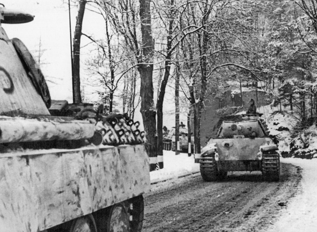 German Panther tanks roll along an unpaved road that has been hardened by freezing winter temperatures during the Battle of the Bulge.