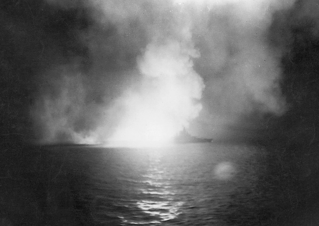 The victim of multiple Japanese torpedo hits at Pearl Harbor, the battleship USS West Virginia was raised from the bottom of the harbor and repaired to fight again. In this photo, West Virginia is illuminated as her guns take a toll on the Japanese during the Battle of Surigao Strait three years after Pearl Harbor. 