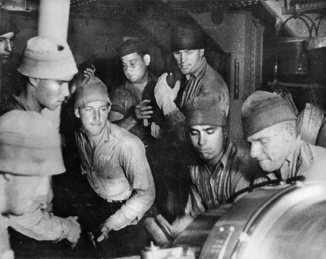 A casemate gun crew services its 5-inch weapon while a line of sailors passes ammunition forward. The 5-inch gun was the main armament of many American destroyers during World War II. 