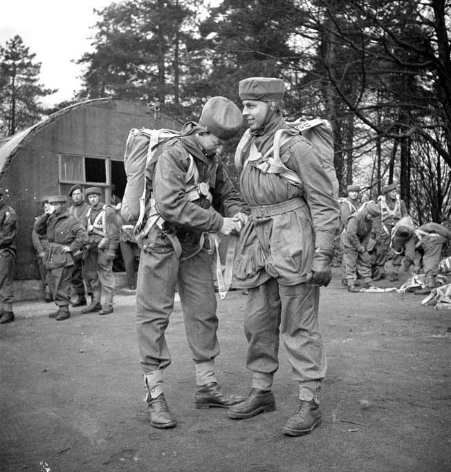 During a training exercise in April 1944, Major H. Fraser helps Lieutenant R.C. Hilborn of the 1st Canadian Parachute Battalion adjust his harness. This jump was conducted from a static balloon.